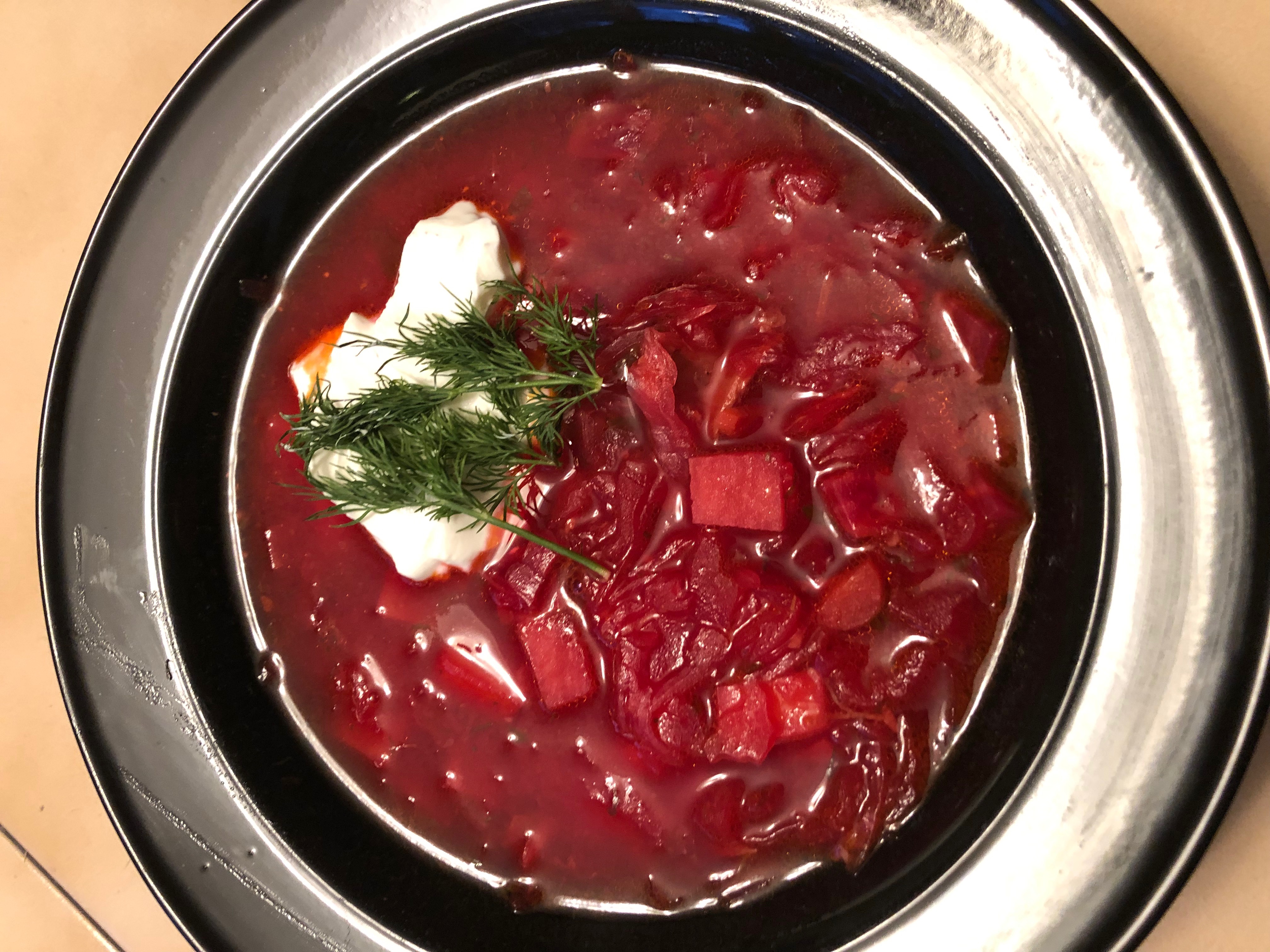 A bowl of beat soup, red and gorgeous, with sour cream and dill